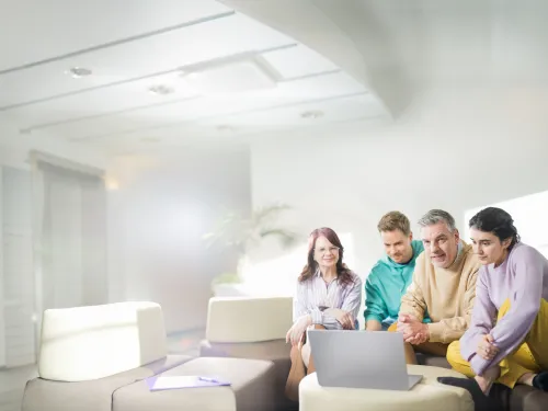 Neljä ihmistä katsoo tietokonetta